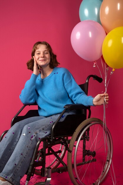 Retrato de mujer discapacitada en silla de ruedas con globos