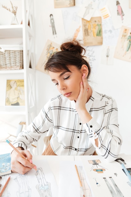 Retrato de una mujer diseñadora de moda creativa que trabaja en el taller