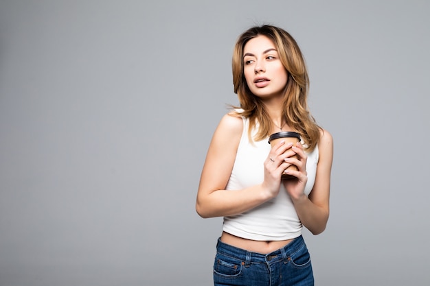 Retrato de mujer disfruta sosteniendo la taza de té café aislado en la pared gris