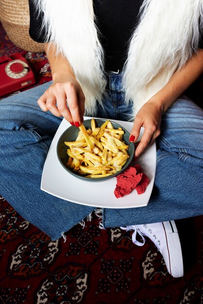 Retrato de mujer disfrutando de un plato de poutine