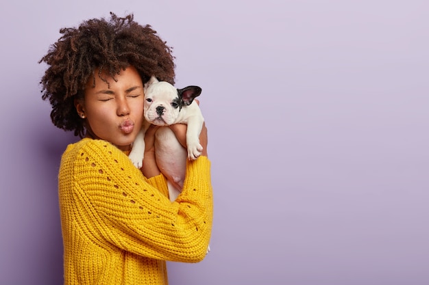 Retrato de mujer divertida pasa tiempo libre con su amado cachorro bulldog