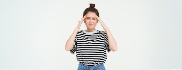 Foto gratuita retrato de una mujer con dolor de cabeza que toca la frente y frunce el ceño por la incomodidad.