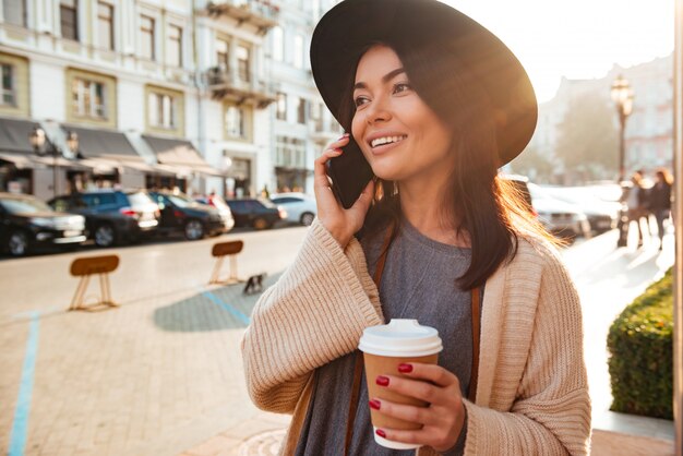 Retrato de una mujer elegante alegre hablando por teléfono móvil