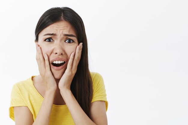 Retrato de mujer elegante preocupada y desilusionada disgustada en camisa amarilla de moda gritando de shock