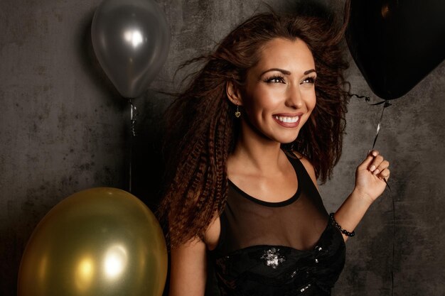 Retrato de mujer elegante sonriente con globos en la fiesta