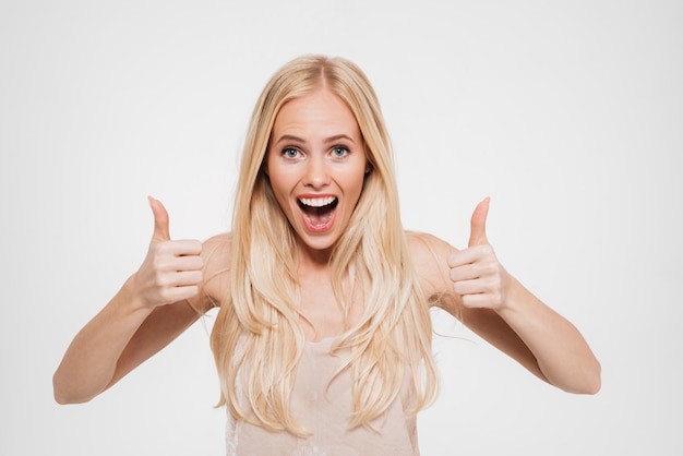 Retrato de una mujer emocionada feliz mostrando los pulgares para arriba