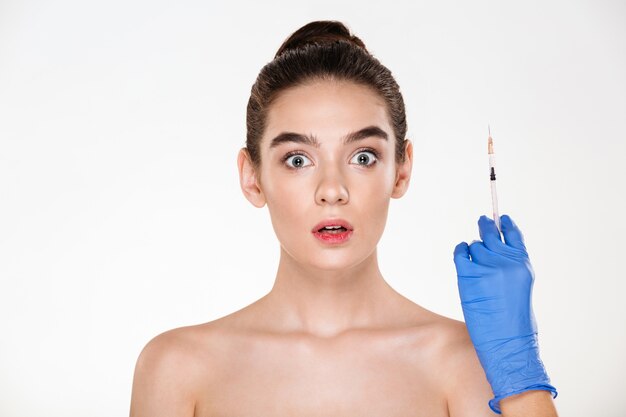 Retrato de mujer emocionada o asustada preparándose para inyecciones de ácido hialurónico en la cara con tratamiento de cuidado de la piel en la clínica