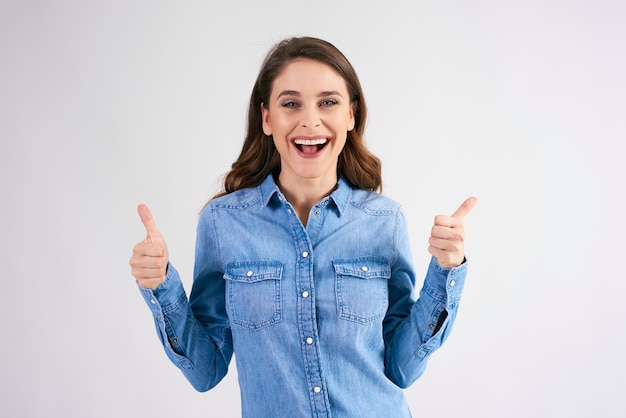 Retrato de mujer emocionada con los pulgares para arriba