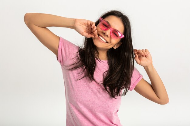 Retrato de mujer emocional muy sonriente en camisa rosa y elegantes gafas de sol, dientes blancos, posando positivo aislado