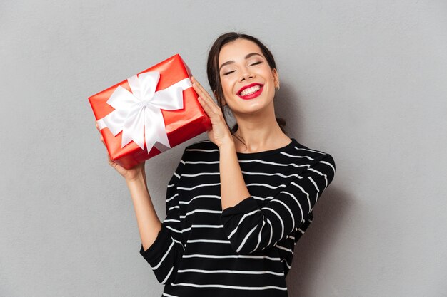 Retrato de una mujer encantada con caja de regalo