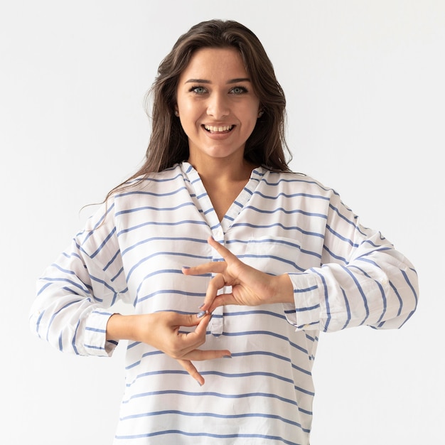 Foto gratuita retrato de mujer enseñando lenguaje de señas