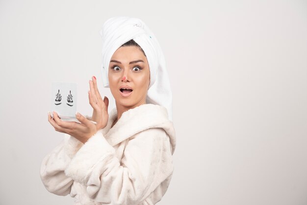 Retrato de mujer envuelta en una toalla blanca con paleta de sombras de ojos