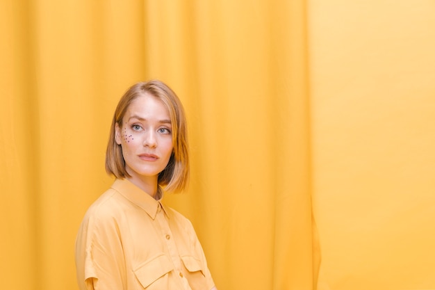 Retrato de mujer en un escenario amarillo