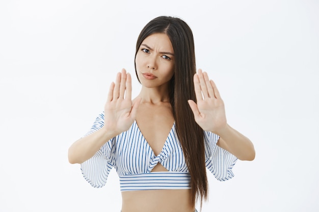 Retrato de mujer estricta de aspecto serio disgustado con cabello largo oscuro frunciendo el ceño y frunciendo los labios