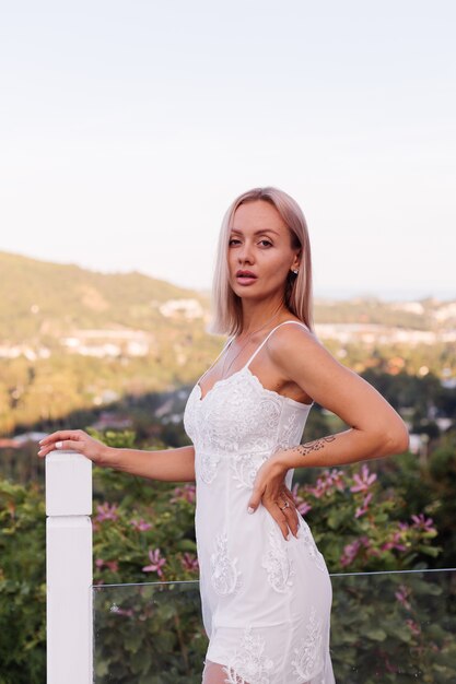 Retrato de mujer europea en vestido de novia con collar y anillo.