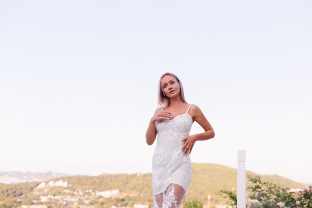 Retrato de mujer europea en vestido de novia con collar y anillo.