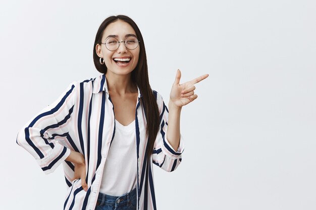 Retrato de mujer exitosa adulta feliz y despreocupada en elegante blusa sobre camiseta y gafas, riendo alegremente