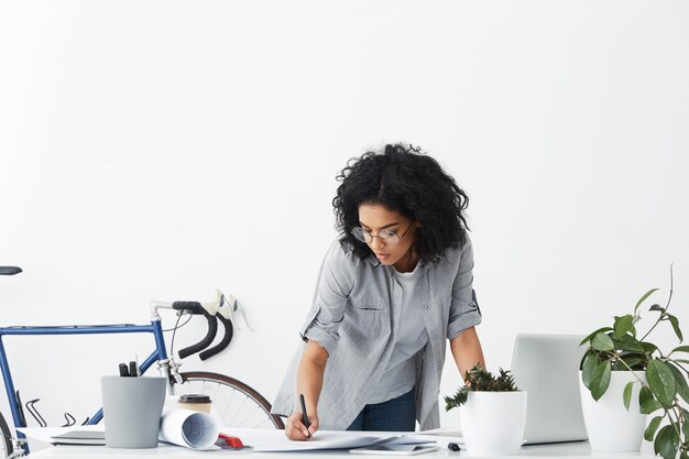 Retrato de mujer exitosa ingeniero con cabello rizado oscuro vistiendo camisa casual