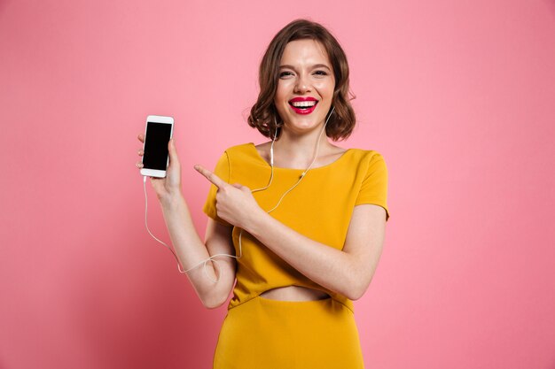 Retrato de una mujer feliz en auriculares escuchando música