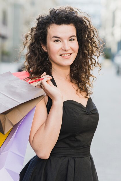 Retrato de una mujer feliz con bolsas de compras