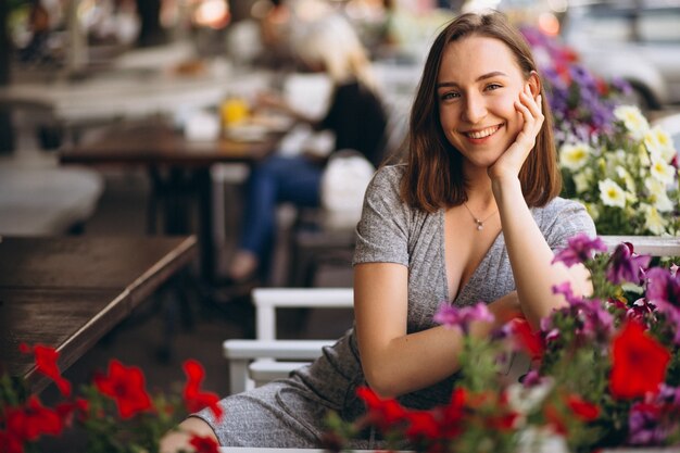 Retrato de una mujer feliz en un café con flores