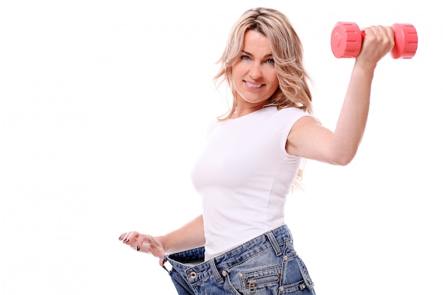 Foto gratuita retrato de mujer feliz envejecida con jeans grandes y pesa