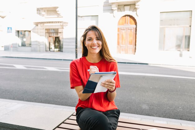 Retrato de una mujer feliz escribiendo notas en el diario