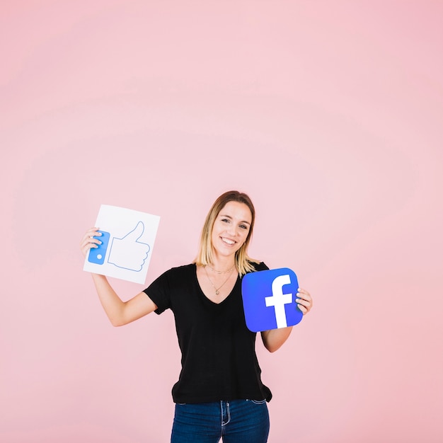 Retrato de una mujer feliz con facebook icono de pulgares arriba