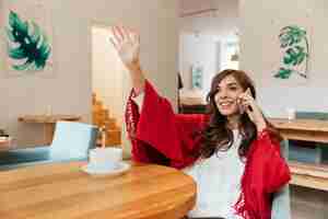 Foto gratuita retrato de una mujer feliz hablando por teléfono móvil