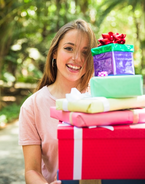 Retrato de una mujer feliz con pila de regalos