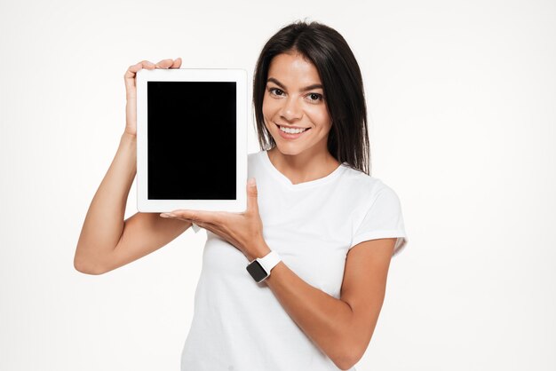 Retrato de una mujer feliz que presenta tableta de pantalla en blanco