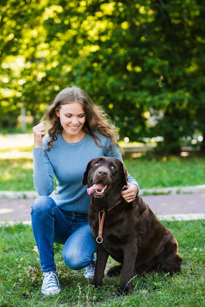 Retrato de una mujer feliz y su perro en el jardín