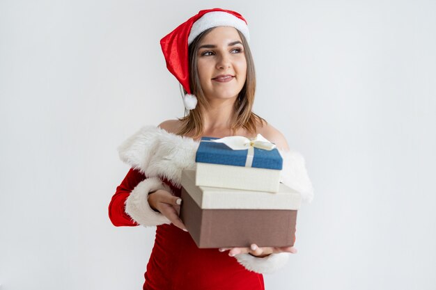 Retrato de mujer feliz en traje de Papá Noel con montón de cajas