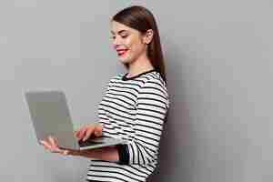 Foto gratuita retrato de una mujer feliz usando la computadora portátil