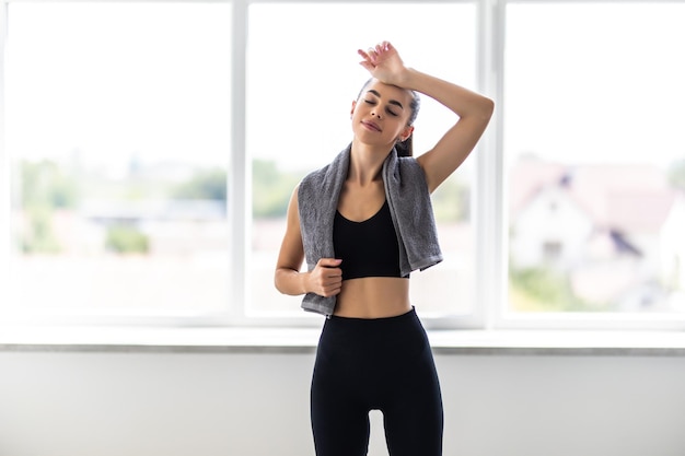 Retrato de una mujer fitness feliz con toalla aislado sobre un fondo blanco.