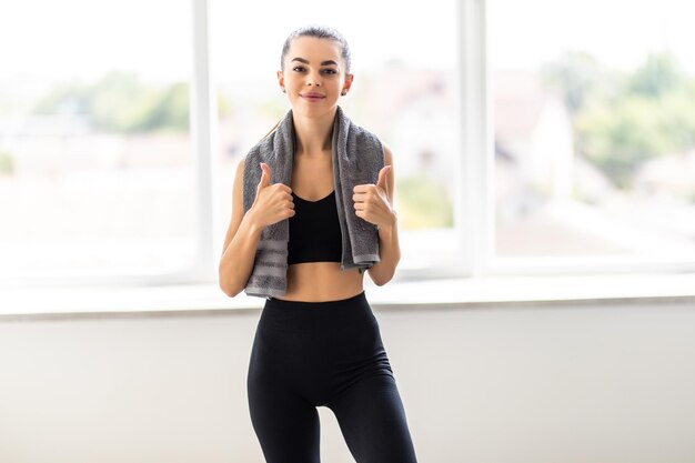 Retrato de una mujer fitness feliz con toalla aislado sobre un fondo blanco.