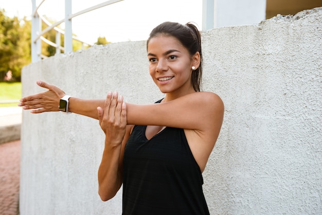 Retrato de una mujer fitness smilng estirando sus manos