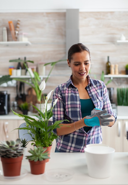 Retrato de mujer floristería que trabaja en casa con guantes de jardinería