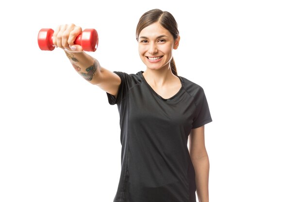 Retrato de mujer fuerte y atractiva haciendo ejercicio con pesas sobre fondo blanco.