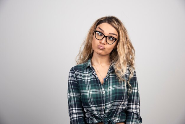 Retrato de mujer con gafas de moda haciendo cara de tonto.