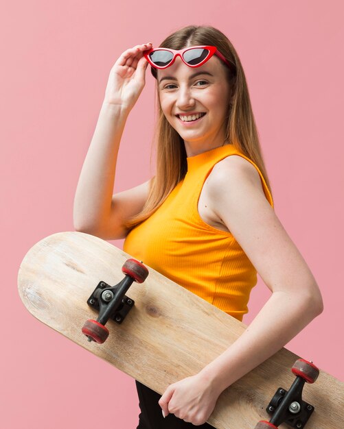 Retrato de mujer con gafas de sol y patineta