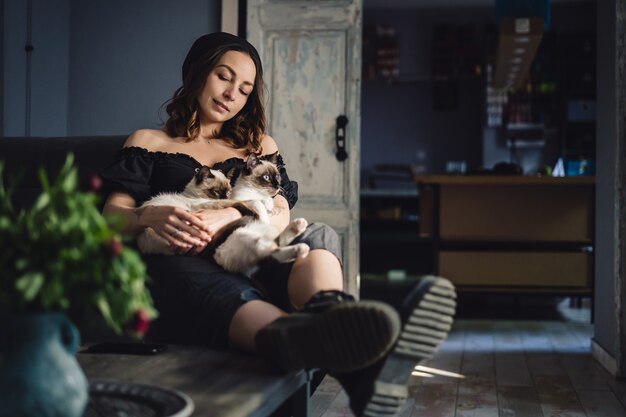 Retrato mujer con gatos siameses