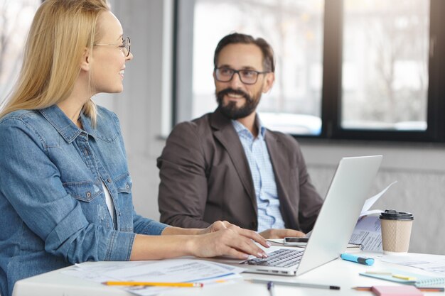 Retrato de mujer gerente y su jefe trabajando juntos en la oficina