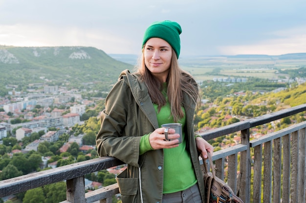 Retrato de mujer con gorro con taza termo