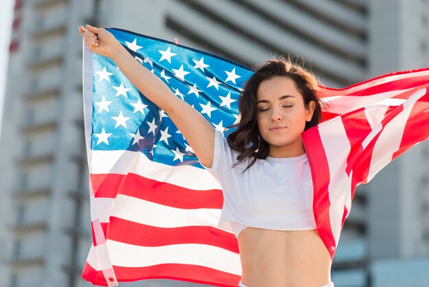 Retrato de mujer con gran bandera de Estados Unidos