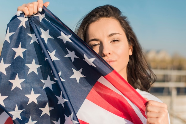 Retrato de mujer con gran bandera de Estados Unidos