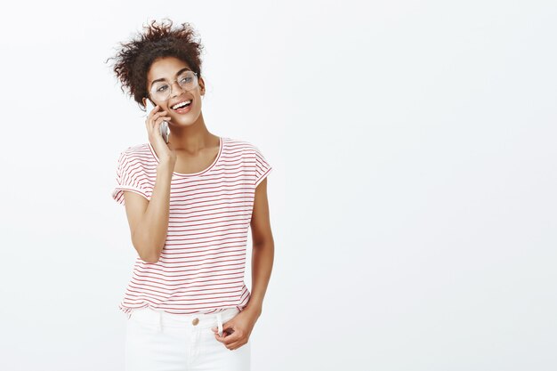 Retrato de mujer guapa habladora con peinado afro posando en el estudio