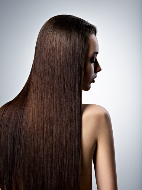 Retrato de mujer hermosa con cabello castaño largo y recto en el estudio