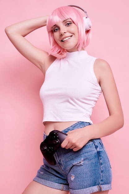 Retrato de mujer hermosa con cabello rosado disfruta de la música en auriculares