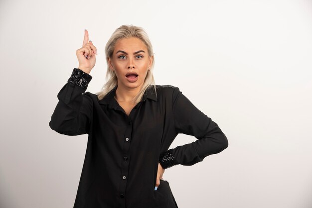 Retrato de mujer hermosa en camisa negra posando sobre fondo blanco. Foto de alta calidad